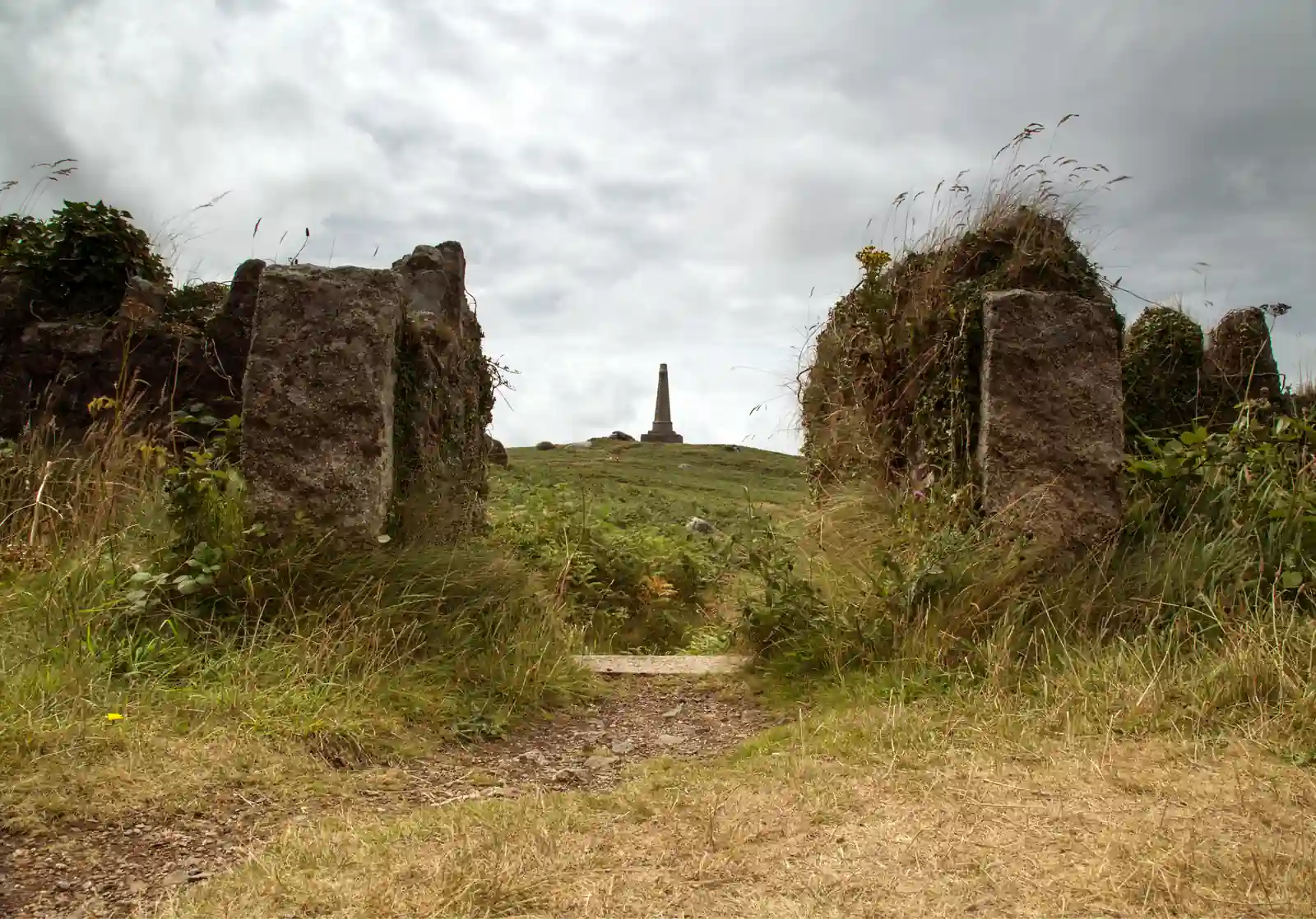 The monument on Carn Brea seen through a granite stile above Redruth